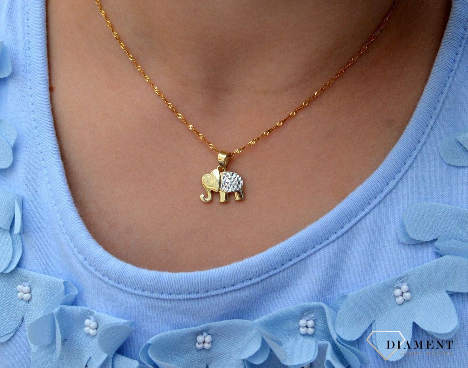 Złota zawieszka 333 słoń z białym złotem ZA 6873 333. Piękno zawarte w subtelnym detalu, w postaci zawieszki o kształcie słonia. Utrzymana w najnowszych trendach złota biżuteria inspirowana motywem amuletów, to oryginalny do.jpg